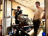 James Penna and Finn van Donkelaar stand beside a complicated-looking Jet Gun prototype in the back of a panel truck